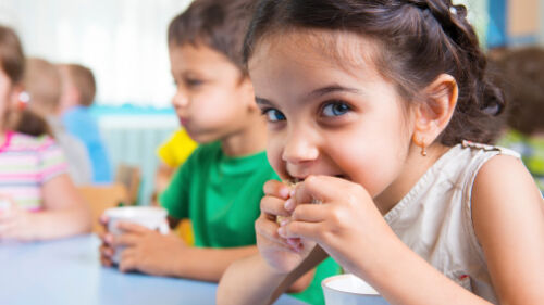 Cute little children drinking milk at daycare